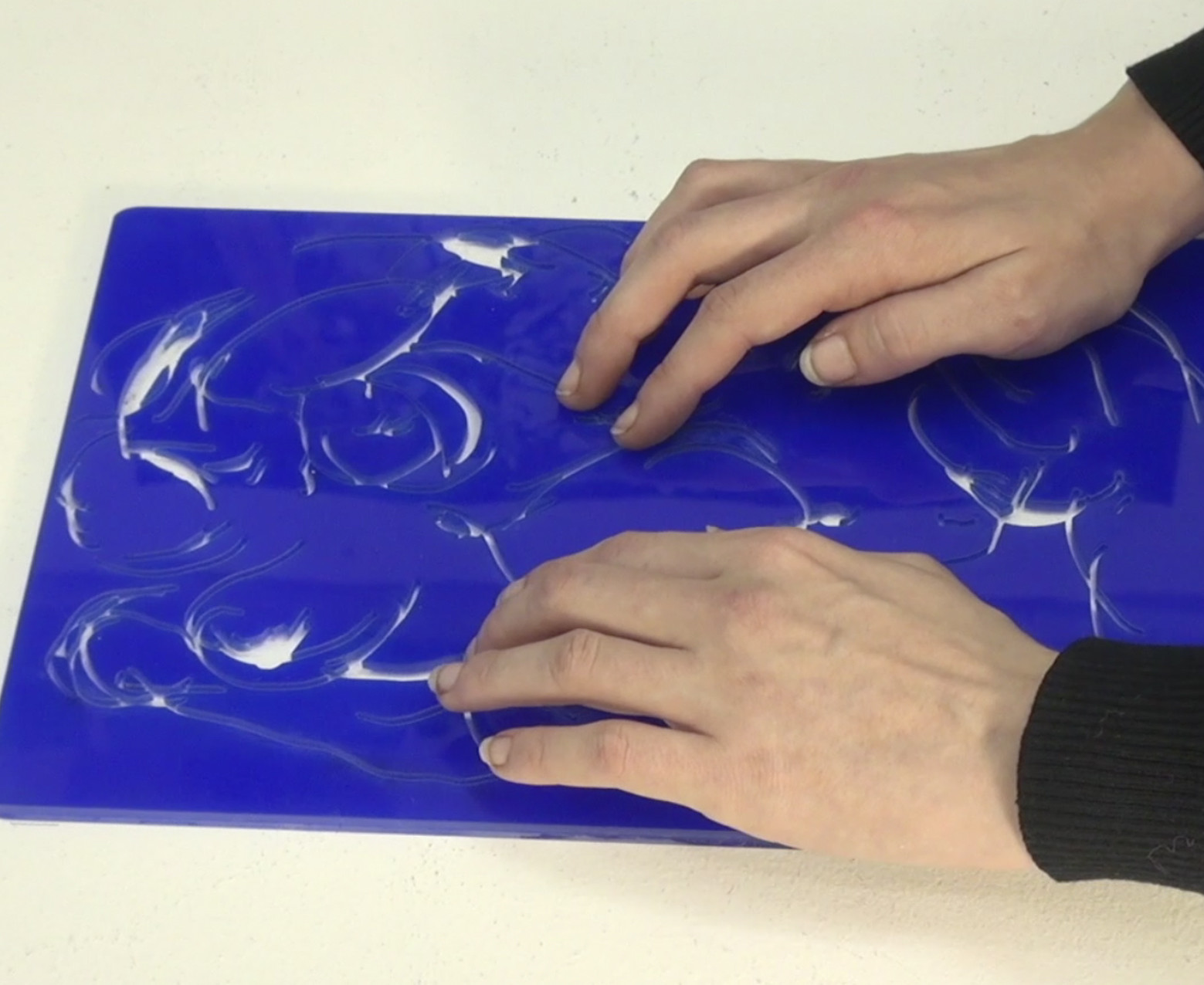 - Je suis revenue ici, je n'en n'ai pas forcément parlé, c'est justement le muscle ( mollet ) et j'ai le muscle chez moi qui passe par dessus le tibia ; il est bien représenté là sur le côté  et là le muscle du mollet. -  C'est quand même étonnant ta capacité à te retrouver et à te situer dans l'espace et dans le volume . -  J'ai toujours eu une certaine concentration au détail, en fait je suis perfectionniste. Dans mon travail on m'a souvent dit que ça se voyait. Je prends du temps à faire les choses. J'essaye aussi de faire en sorte de les faire de la façon la plus facile, possible, pour gagner du temps et en même temps de faire les choses de façon précise. Essayer d'avoir plus d'évolution et d'efficacité dans le travail. Là j'ai le creux… C'est pas le sein, on pourrait croire, c'est en dessous, en fait j'ai une côte qui creuse vraiment, Au final sur le plexiglass, c'est présent. Ça va peut être paraître bizarre, mais psychologiquement ça me le fait plus assumer, parce que avec l'ensemble de ce comment ça a été gravé, je trouve que c'est sympa, c'est très arrondi, très particulier ; on voit certains détails, c'est un peu comme l'énigme de votre corps, en fait, divisé en plusieurs parties et quand vous le remettez en UN et bien c'est, la réponse dans l'ensemble de votre corps, pas visuellement mais au toucher, et c'est super-intéressant, franchement encore une fois ; Je trouve mon corps bien plus beau comme ceci qu' en photo.